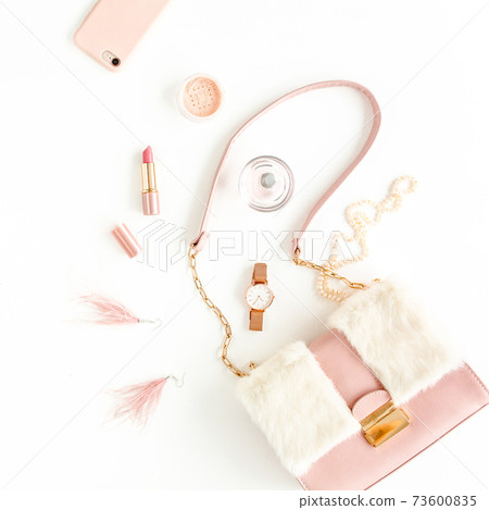 Women's pink bag with fashion trendy accessories: watch, perfume, phone, lipstick, earrings on white background. Flat lay, top view 73600835