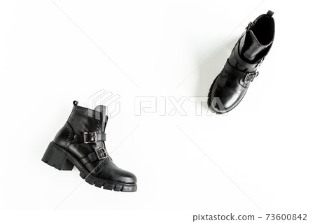 Black female boots on white background. Flat lay, top view minimal background. Fashion blog or magazine concept. 73600842