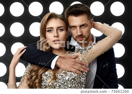 couple posing against the backdrop of spotlights 73601200
