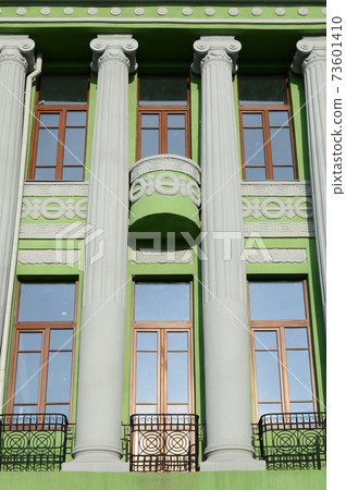 Restored old multi-storey building with antique columns, painted in green Restored old multi-storey building with antique columns, painted in green 73601410