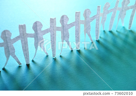Kirigami of people who are connected by sandwiching a tsuitate with the new corona measures. Blue background and copy space. 73602010