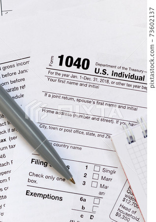 The pen and notebook is lies on the tax form 1040 U.S. Individual Income Tax Return. The time to pay taxes The pen and notebook is lies on the tax form 1040 U.S. Individual Income Tax Return. The time to pay taxes 73602137