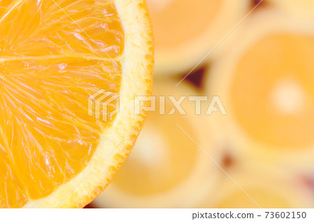 Top view of a fragment of the orange fruit slice on the background of many blurred orange slices. A saturated citrus texture image Top view of a fragment of the orange fruit slice on the background of many blurred orange slices. A saturated citrus texture image 73602150