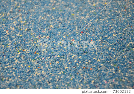 Texture of a colored granular sand close up. Blue grains 73602152