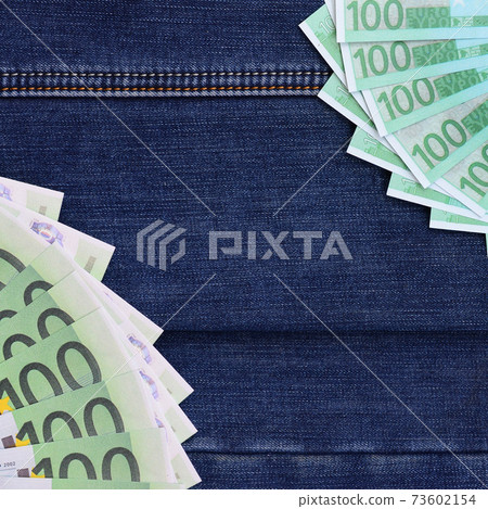 The fan of a lot of euro bills is on a dark denim surface. Background image The fan of a lot of euro bills is on a dark denim surface. Background image 73602154