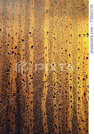 The texture of misted glass with a lot of drops and drips of condensation against the sunlight at dawn. Background image 73602156