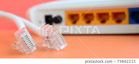 Internet router and Internet cable plugs lie on a bright orange background. Items required for Internet connection 73602215
