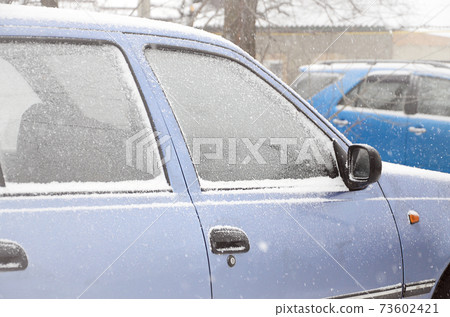 Fragments of parked cars covered with snow Fragments of parked cars covered with snow 73602421