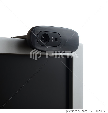 A modern web camera is installed on the body of a flat screen monitor. Device for video communication and recording of high quality video 73602467