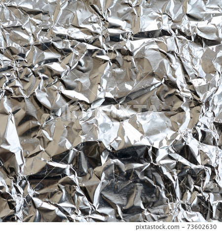 Thin wrinkled sheet of crushed tin aluminum silver foil background with shiny crumpled surface for texture Thin wrinkled sheet of crushed tin aluminum silver foil background with shiny crumpled surface for texture 73602630