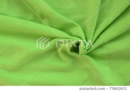 The texture of the fabric is bright green. Material for making shirts and blouses 73602631