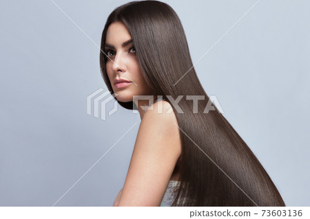 Beautiful brown-haired girl with a perfectly smooth hair, and classic make-up. Beauty face and hair. 73603136