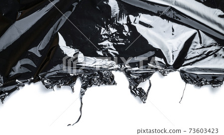 Plastic bag texture. Wrap transparent dark cellophane isolated on white background with copy space. Black shiny film pattern for packaging, product protection. Plastic bag texture. Wrap transparent dark cellophane isolated on white background with copy space. Black shiny film pattern for packaging, product protection. 73603423