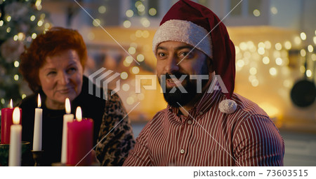 Man with family members on Christmas dinner 73603515