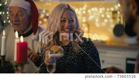 Woman with senior father during Christmas dinner with family 73603516