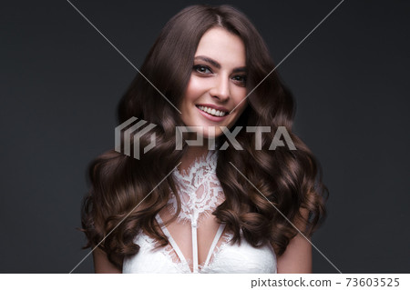 Beautiful brown-haired girl with a perfectly curls hair, and classic make-up. Beauty face and hair. Beautiful brown-haired girl with a perfectly curls hair, and classic make-up. Beauty face and hair. 73603525