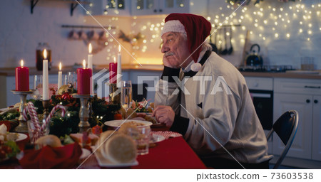Lonely senior man at festive table for Christmas Lonely senior man at festive table for Christmas 73603538