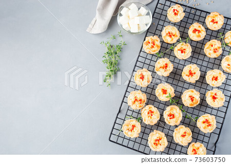 Feta cheese and fried onion mini quiche muffins, on cooling rack,  horizontal, copy space, top view 73603750