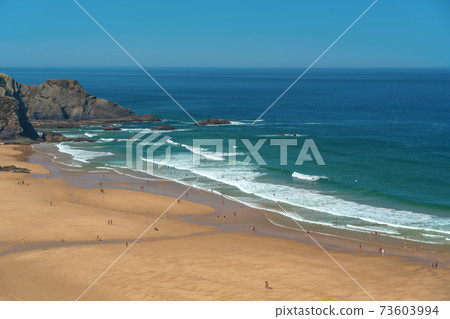 Delightful panoramic view of the Portuguese beach Odeceixe with tourists at the sea. 73603994