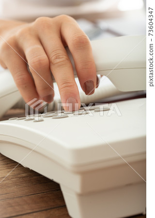 Closeup view of female hand dialing telephone number Closeup view of female hand dialing telephone number 73604347