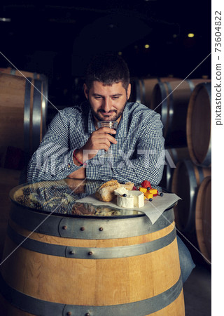 Caucasian man in a winery with barrels Caucasian man in a winery with barrels 73604822