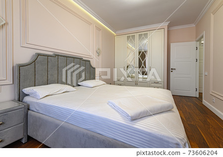 Beige and brown modern bedroom interior with double bed 73606204