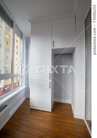 Empty heated penthouse living room with floor to ceiling windows 73606205