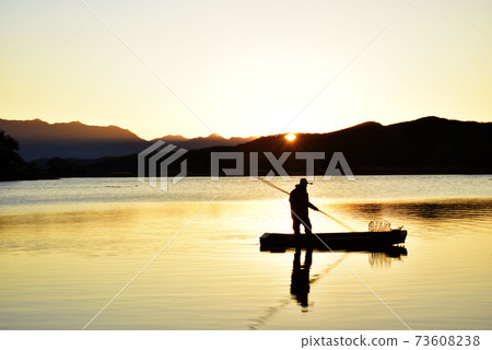 Fisherman opening a quiet lake morning Fisherman opening a quiet lake morning 73608238