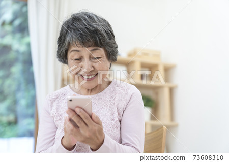 Senior female using a smartphone 73608310