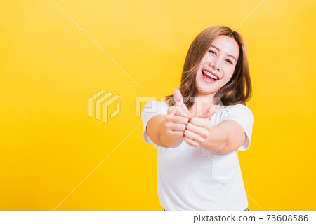 woman smile wear white t-shirt successful woman giving two thumbs up gesture woman smile wear white t-shirt successful woman giving two thumbs up gesture 73608586