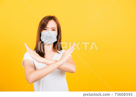 woman wearing face mask protects filter dust pm2.5 anti-pollution, anti-smog, and air pollution her crossed arms show X sign 73608591