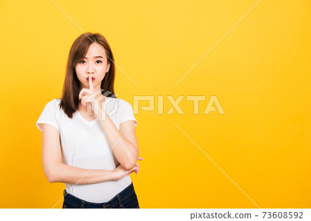 woman teen smile standing wear t-shirt making finger on lips silent quiet gesture woman teen smile standing wear t-shirt making finger on lips silent quiet gesture 73608592