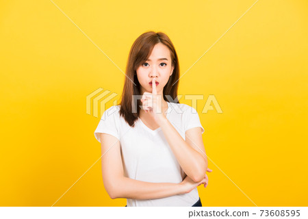 woman teen smile standing wear t-shirt making finger on lips silent quiet gesture woman teen smile standing wear t-shirt making finger on lips silent quiet gesture 73608595