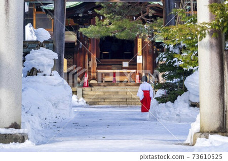 Uesugi Shrine in winter, the approach road with snow and the back of the shrine maiden, Yonezawa City, Yamagata Prefecture Uesugi Shrine in winter, the approach road with snow and the back of the shrine maiden, Yonezawa City, Yamagata Prefecture 73610525