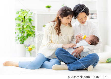 A couple giving milk to their baby 73611162