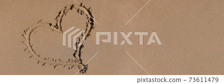 Heart drawn on the sand by sea closeup background 73611479