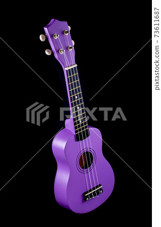 Four string ukulele guitar on black background 73611687