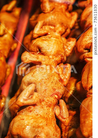 Juicy and flavorful grilled chicken with a golden crust on a skewer in a row. Juicy and flavorful grilled chicken with a golden crust on a skewer in a row. 73611830