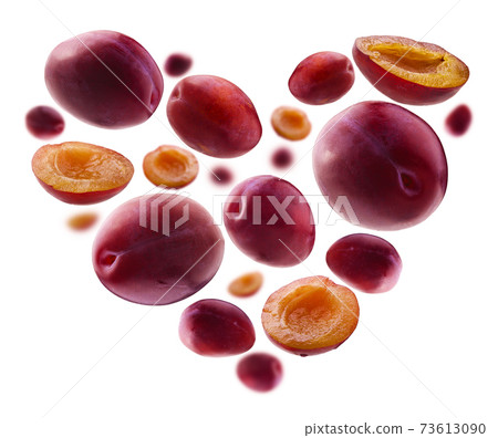 Heart shaped red plums on white background 73613090