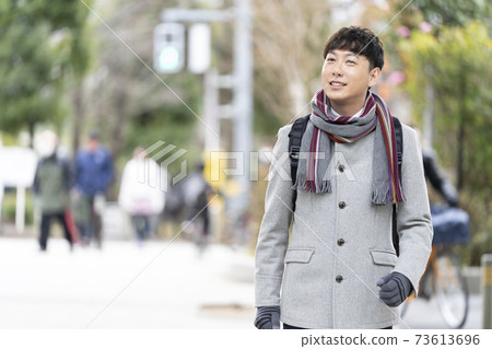 A man in his late 30s wearing a coat A man in his late 30s wearing a coat 73613696