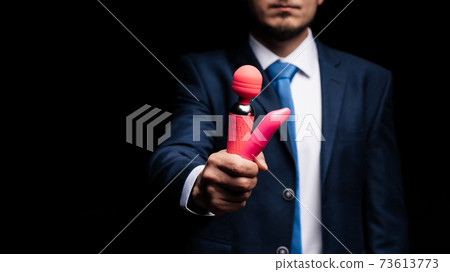 man in a suit is holding pink vibrators for sex 73613773