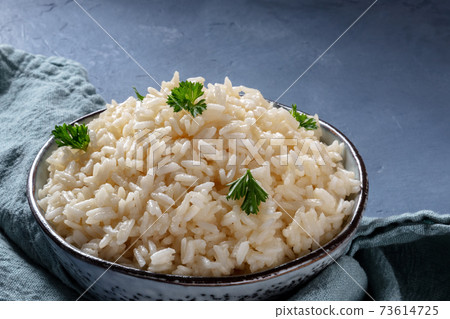 Rice bowl close-up. Cooked rice with parsley leaves Rice bowl close-up. Cooked rice with parsley leaves 73614725