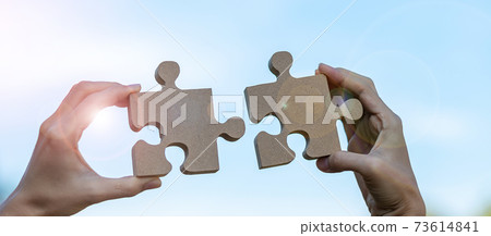 Woman hands connecting couple puzzle piece against sunrise effect, businesswoman holding wood jigsaw with sunset background. Business solutions, target, success, goals and strategy concepts Woman hands connecting couple puzzle piece against sunrise effect, businesswoman holding wood jigsaw with sunset background. Business solutions, target, success, goals and strategy concepts 73614841