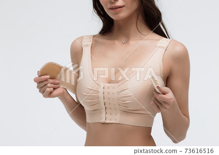 Young woman in beige bra on white background Young woman in beige bra on white background 73616516