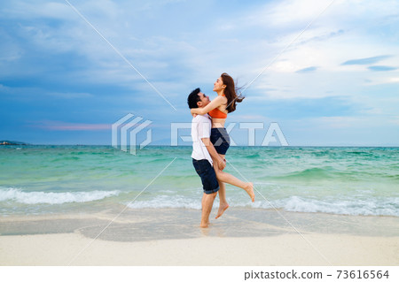 couple picking up and hugging on the sea beach at Koh MunNork Island, Rayong, Thailand couple picking up and hugging on the sea beach at Koh MunNork Island, Rayong, Thailand 73616564