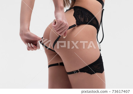 Faceless sexy female with hands on legs posing in studio 73617407