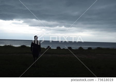 People walking towards the sea 73618019