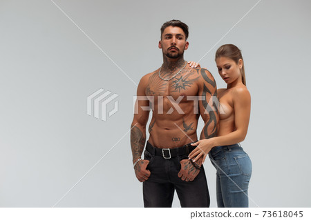 Muscular man hugging topless woman 73618045