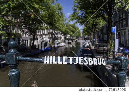 Traditional street sign in Amsterdam, the capital of the Netherlands, overlooking a canal Traditional street sign in Amsterdam, the capital of the Netherlands, overlooking a canal 73618998