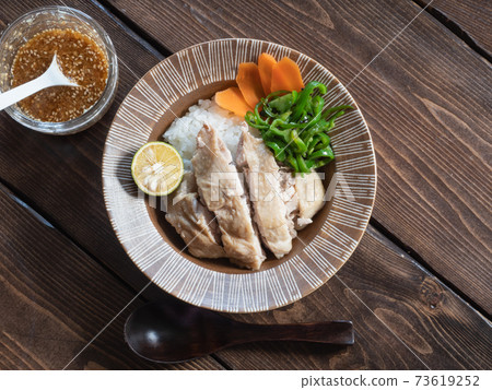 Chicken dish on top of rice, Hainan chicken rice and sauce. Chicken dish on top of rice, Hainan chicken rice and sauce. 73619252